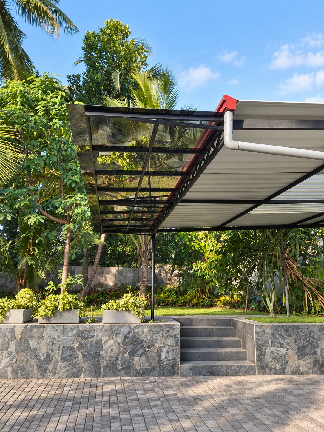 Steel-framed glass-roof canopy over a garden