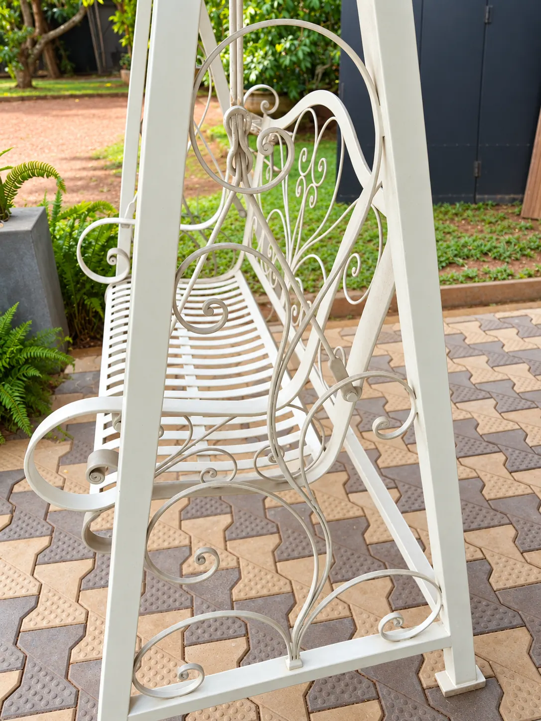 Cream ornate garden swing with timber slat seat